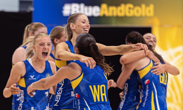 A photo of Team Bath Netball players hugging, smiling and celebrating after their NXT Gen League extra-time victory over Loughborough Lightning in May 2025.