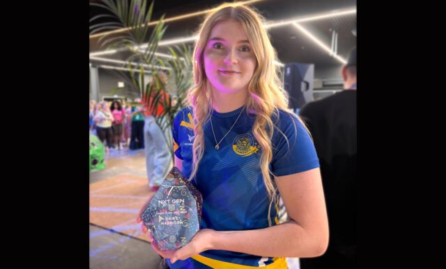 Daisy Harrison, wearing a Team Bath Netball training top, holding the NXT Gen League Player of the Season trophy for 2026