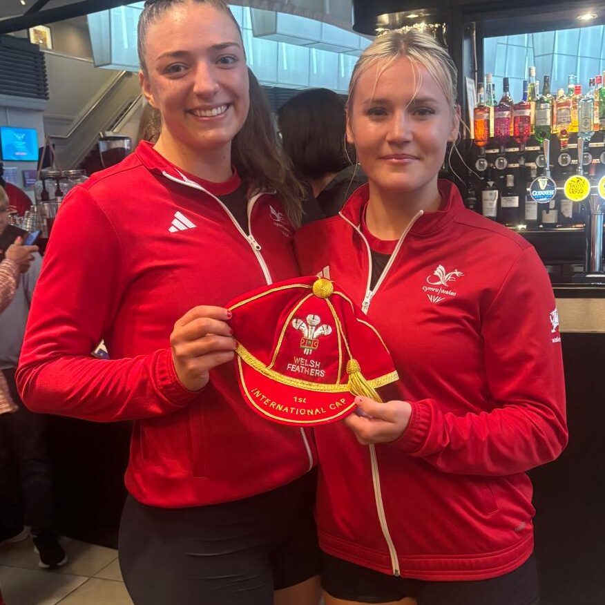 Poppy Tydeman (left) presents a red Wales Netball cap to Lowri Windsor